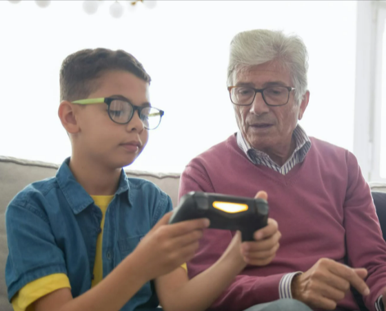 Grey-haired man sitting with his grandson