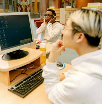 Men in library using computers