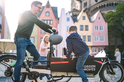Ein Mann mit einem Kind auf einem Lastenrad von Green Moves