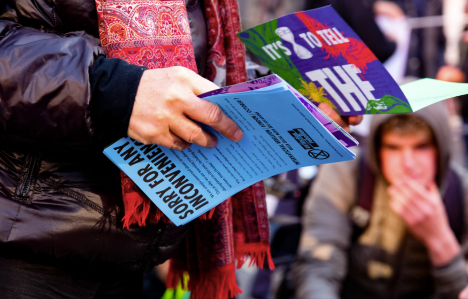 A person holding a flyer with other people around him